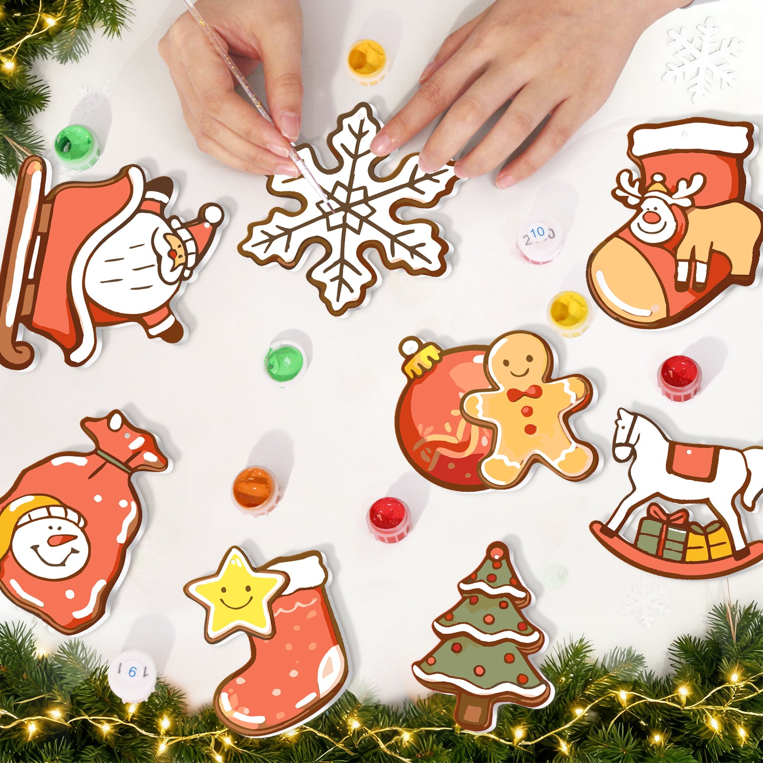 Emporte-pièces sur le thème de Noël sur une surface blanche avec lumières décoratives et verdure.