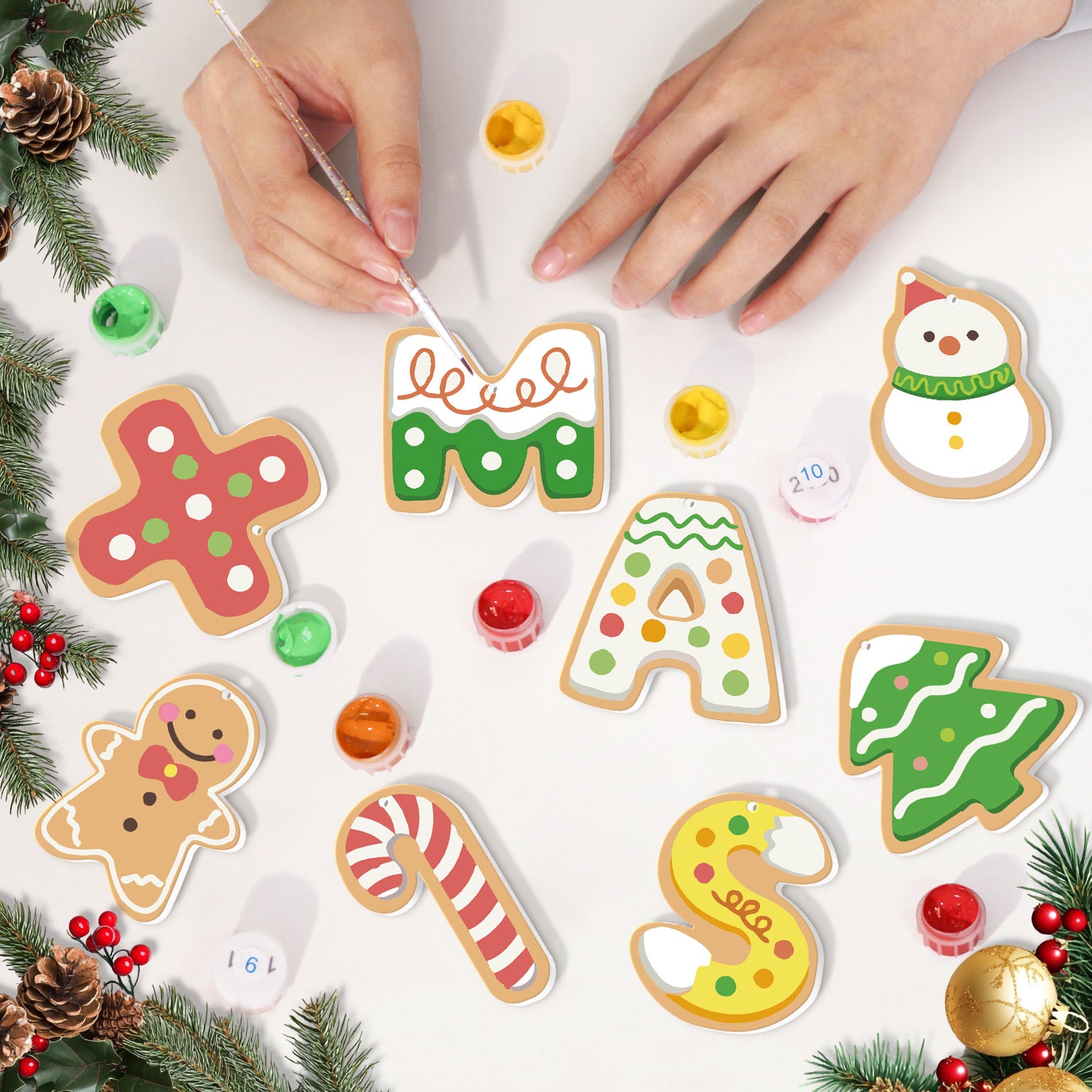 Decorative Christmas cookies with icing being applied on a white surface.