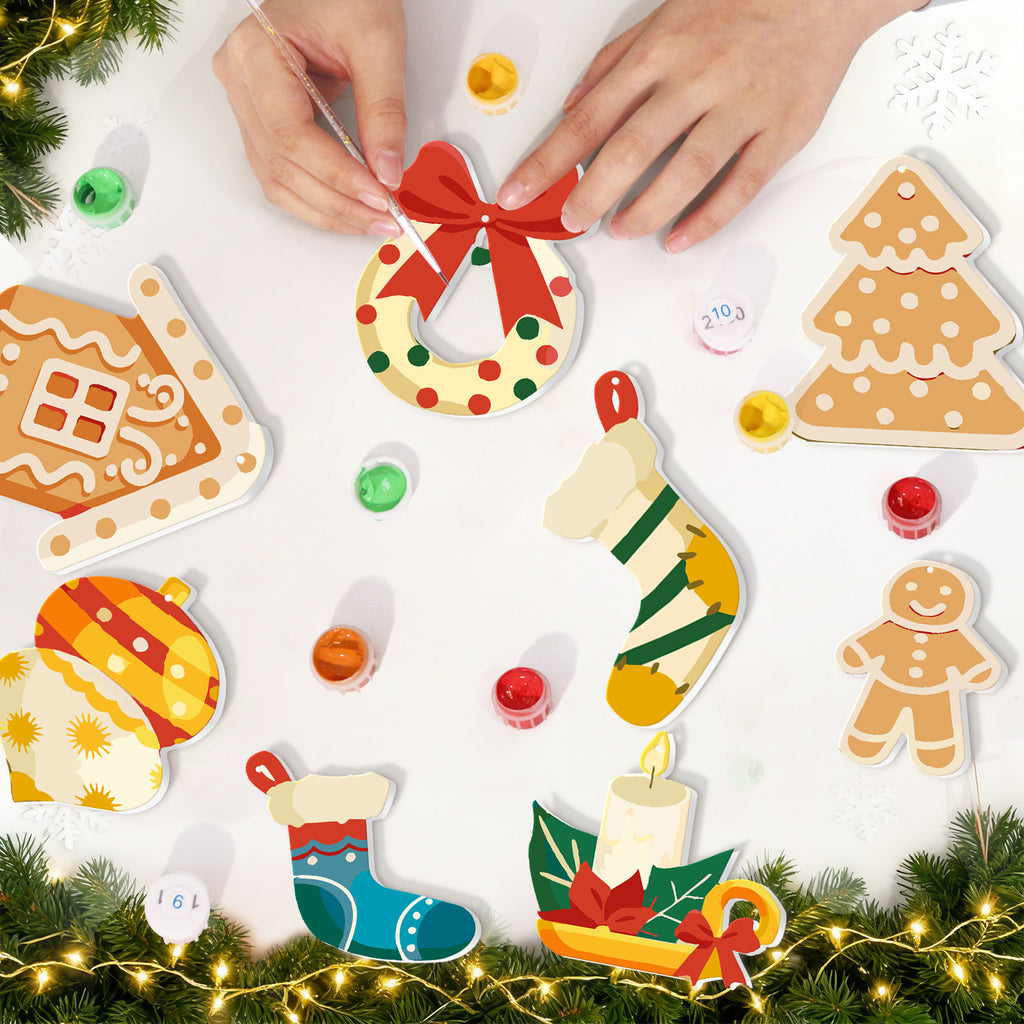 Christmas-themed wooden ornaments with hands arranging them on a white surface.
