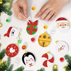 Children's hands decorating Christmas ornaments on a white surface with festive decorations around.