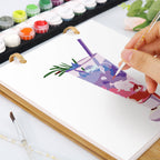 Person painting a colorful abstract design on a canvas with watercolor paints and brushes.