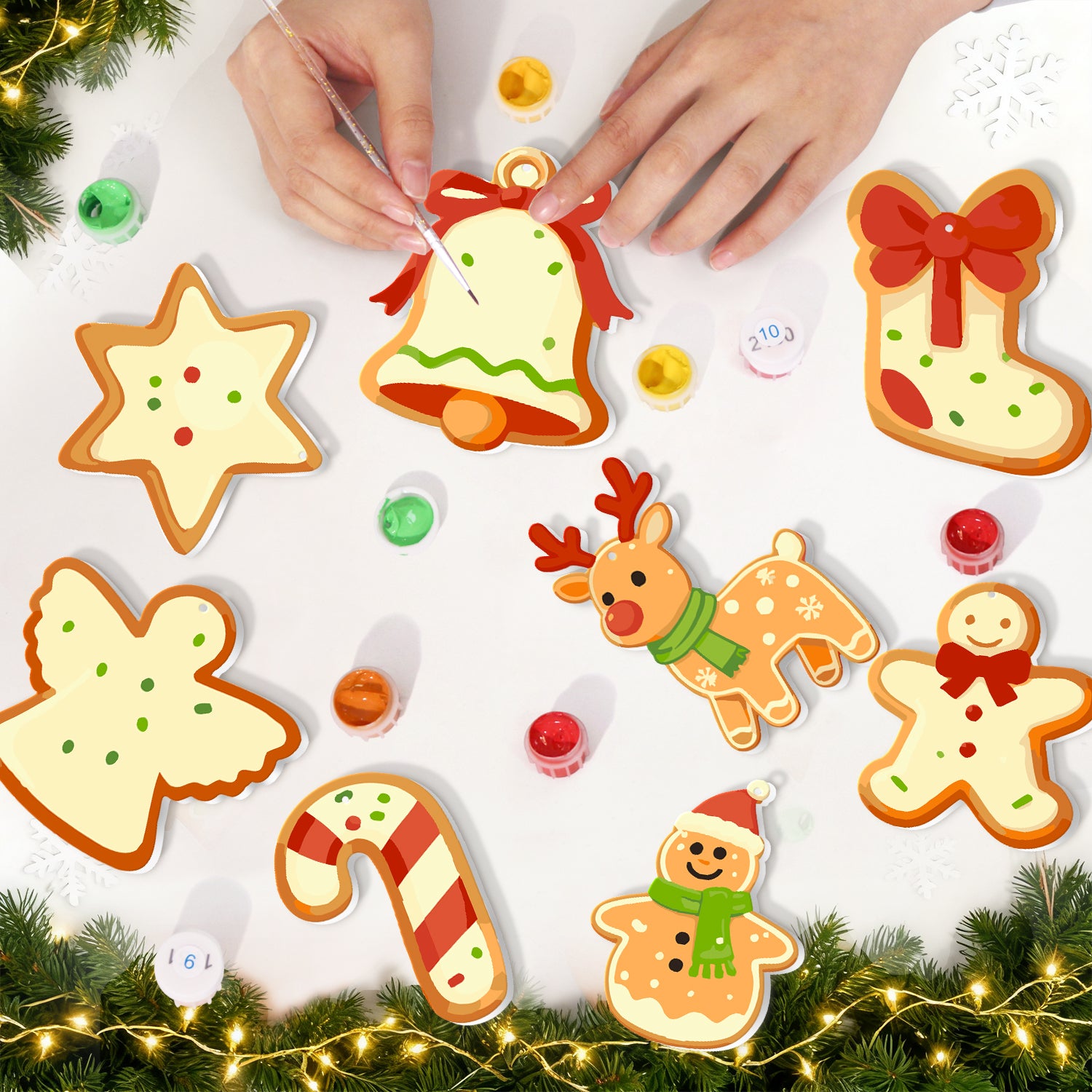 Emporte-pièces sur le thème de Noël sur une surface blanche avec lumières décoratives et verdure.