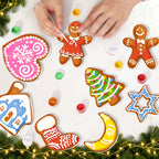 Decorative gingerbread cookies shaped like various Christmas elements on a white surface with festive lights and greenery.