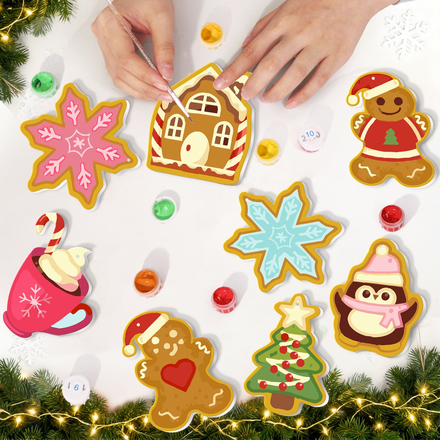 Decorative Christmas cookies shaped like gingerbread men, snowflakes, and a tree on a white surface with hands arranging them.
