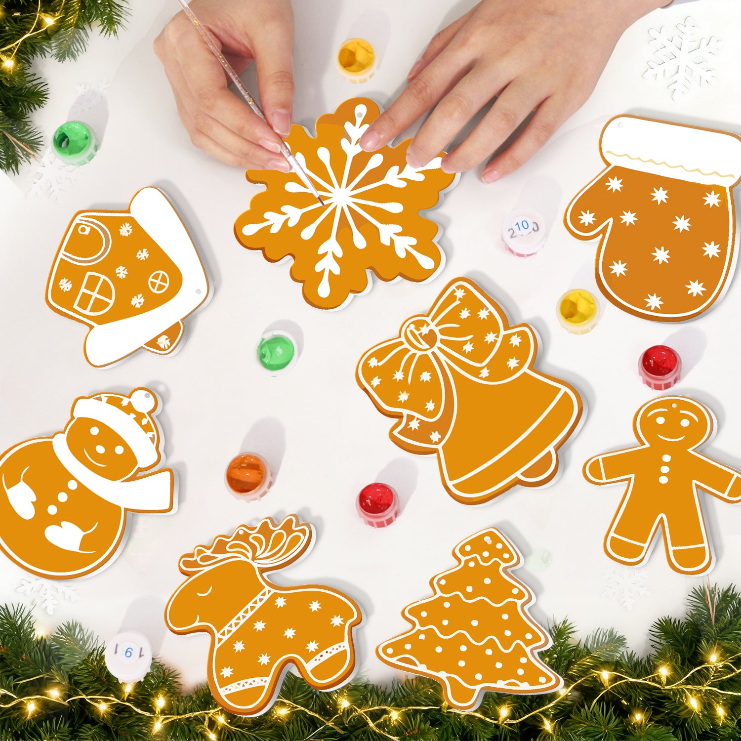 Biscuits décoratifs sur le thème du pain d'épice sur une surface blanche avec des décorations de Noël.