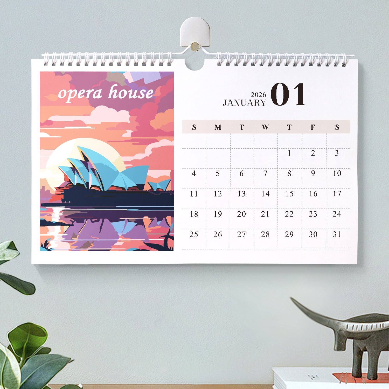 Wall calendar with Sydney Opera House design on a light gray wall.