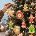 Hand decorating a Christmas tree with gingerbread-themed ornaments.