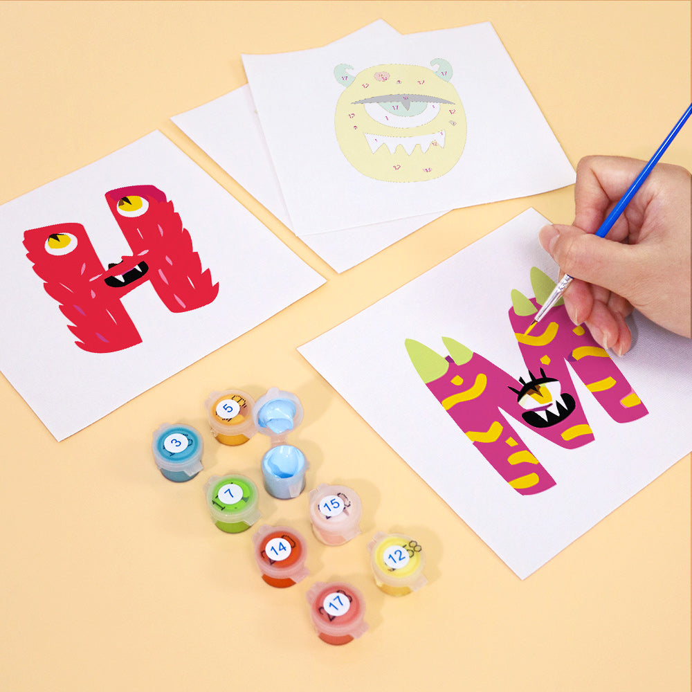 Children's art project with colorful letters 'H' and 'M' on paper, surrounded by paint containers.