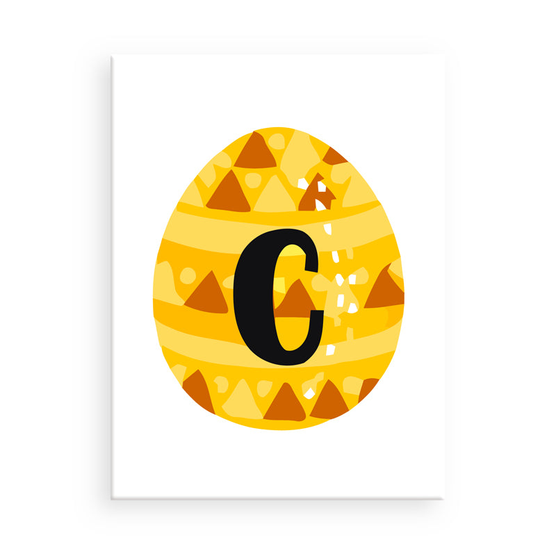 Gelbes Deko-Ei mit schwarzem Buchstaben „C“ auf weißem Hintergrund