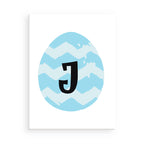 Framed artwork with a blue zigzag pattern and black letter 'J' on a white background