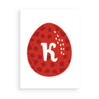 Red Easter egg with a white letter 'K' on a white background