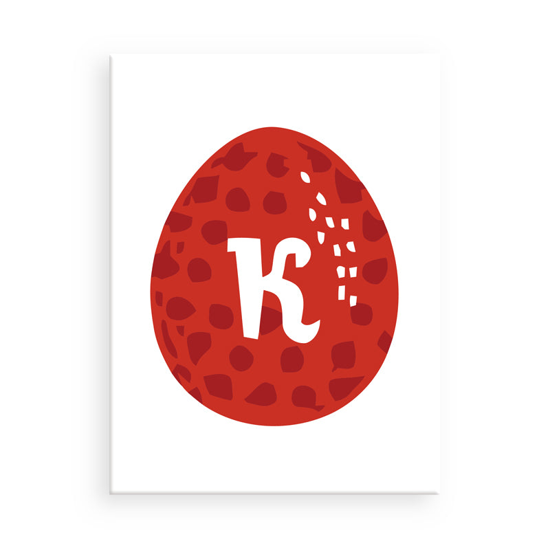 Rotes Osterei mit weißem Buchstaben „K“ auf weißem Hintergrund
