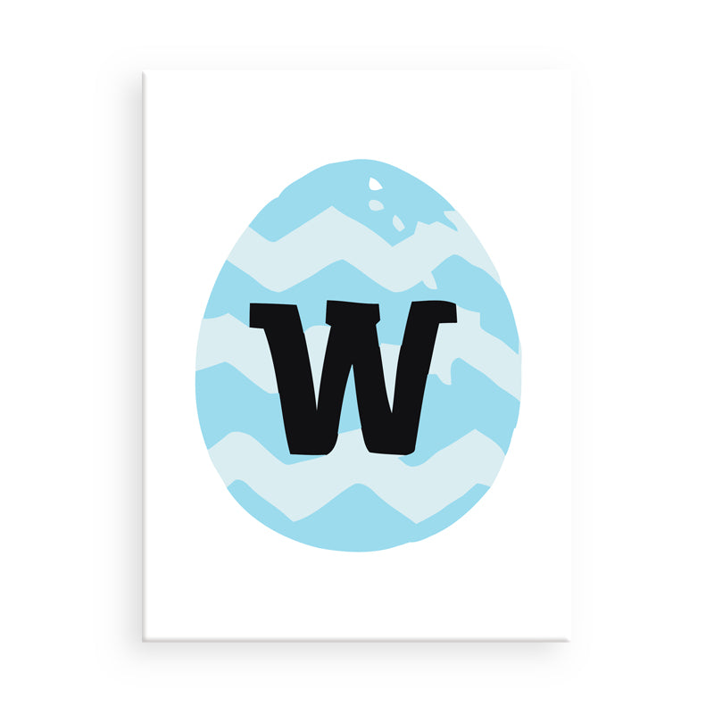 Easter egg with blue chevron pattern and black letter 'W' on a white background