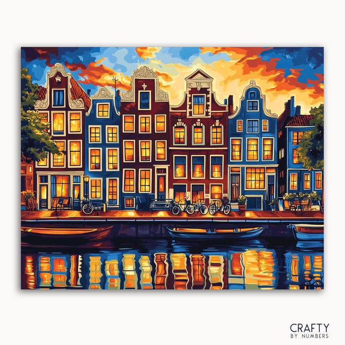 A paint-by-numbers kit depicting the iconic canal houses of Amsterdam illuminated at twilight with a reflection in the water.