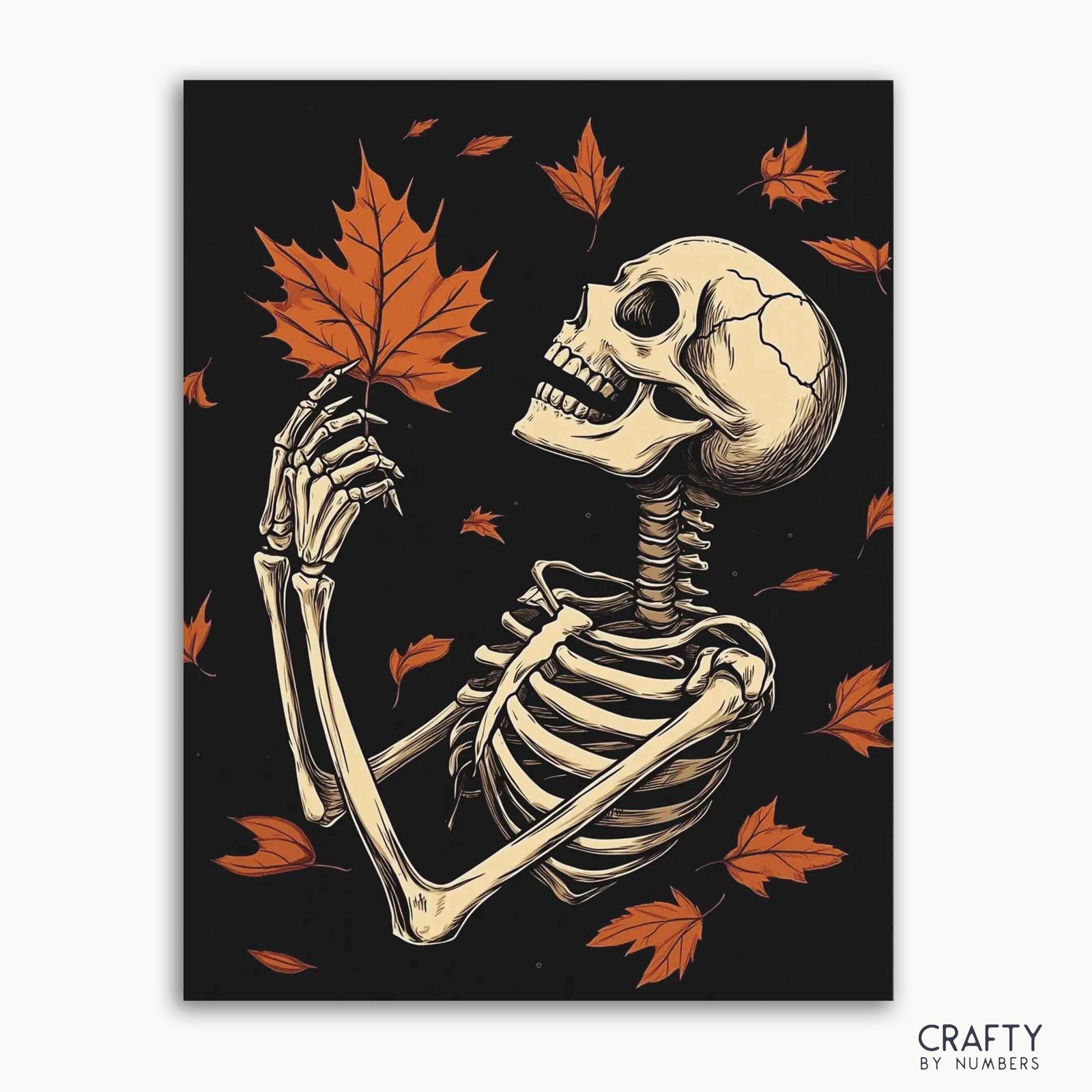 Un kit de pintura por números que presenta un esqueleto sosteniendo una hoja de otoño, con más hojas esparcidas sobre un fondo negro.