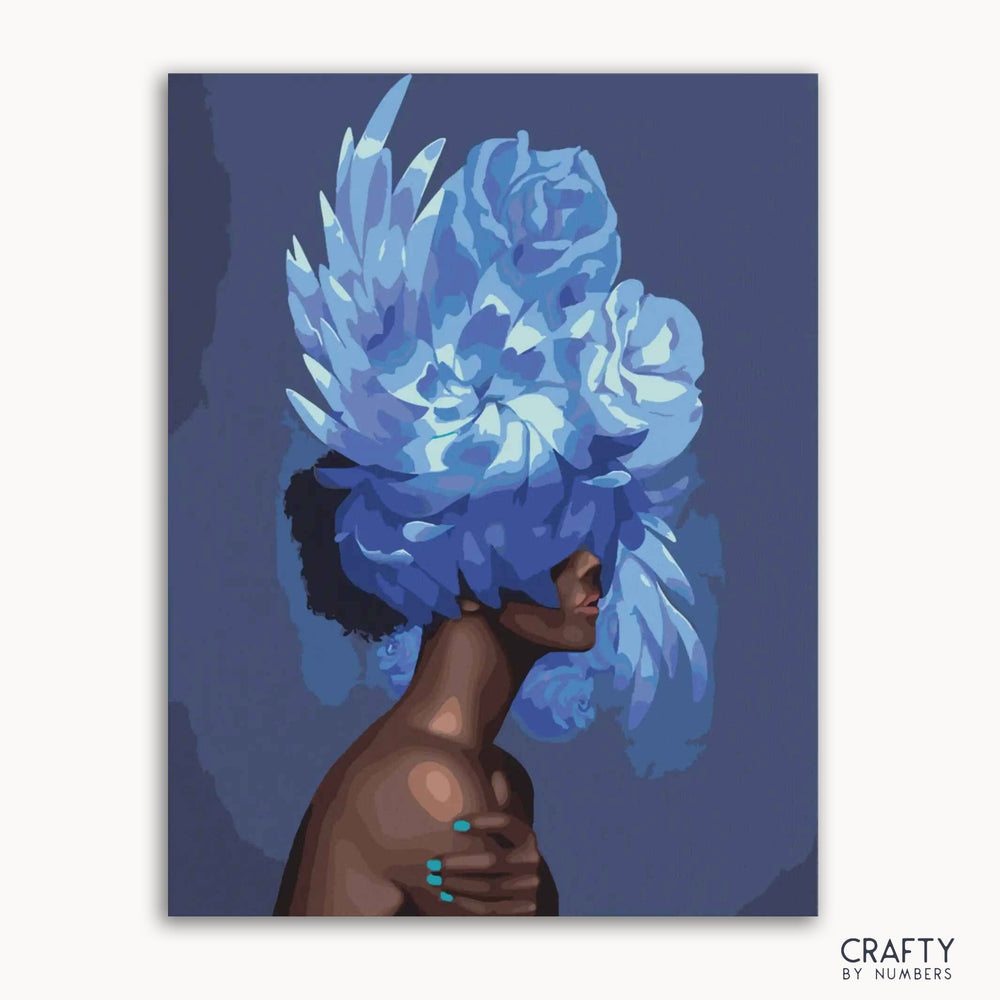 A paint-by-numbers kit depicting a figure with a blue floral arrangement as a hat, with segments marked for painting.