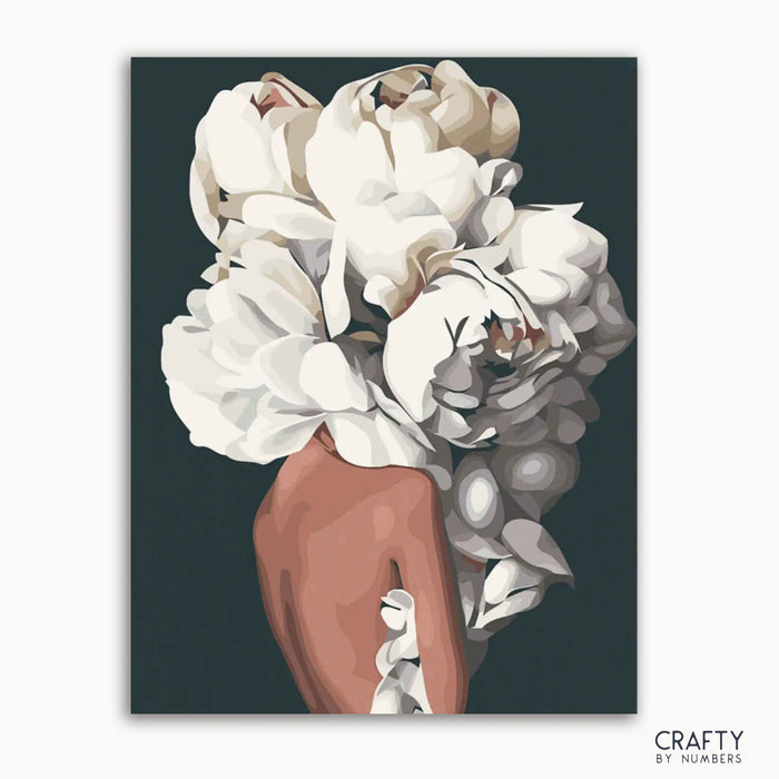 A canvas with a floral paint by numbers kit, featuring white and pink petals against a black background, labeled 'CRAFTY by NUMBERS'.