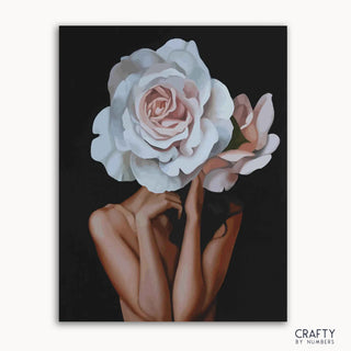 Un kit de peinture par numéros sur toile représentant une femme tenant une rose blanche sur fond noir, avec la marque « Crafty by Numbers » visible.