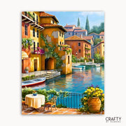 Colorful Italian village scene with canal, buildings, and a cafe.