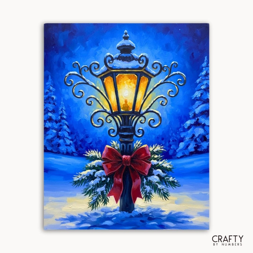 An ornate glowing street lamp with a red bow in blue winter snow, shown as a paint by numbers canvas.