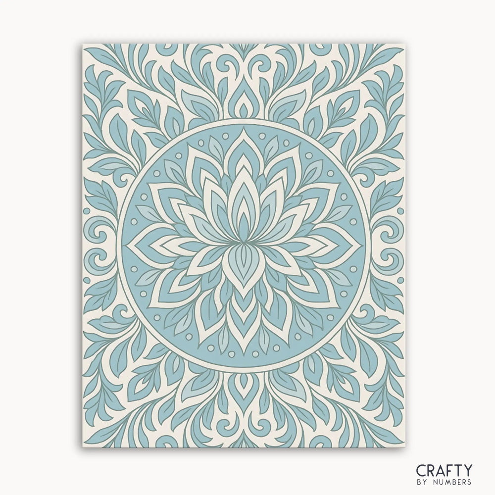 Frosted Grace Mandala Paint by Numbers kit featuring a cool-toned mandala with blue petals and flowing lines on a soft ivory background, evoking a winter bloom