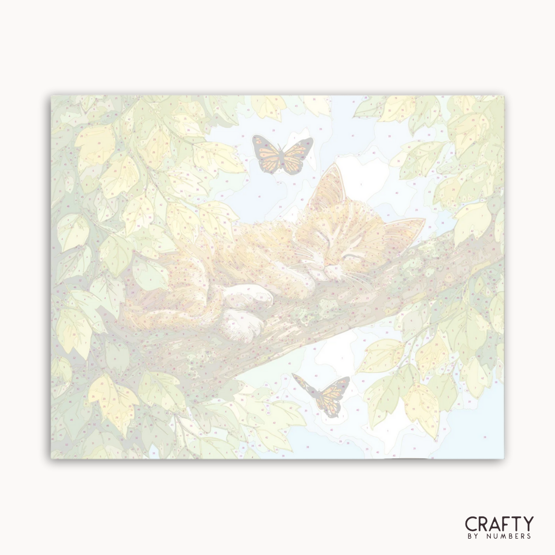 Illustration einer auf einem Ast liegenden Katze mit Schmetterlingen in einem Design mit Naturmotiv und der Marke „Crafty by Numbers“.
