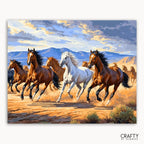 Painting of horses running on a desert landscape with mountains in the background, featuring the brand 'Crafty by Numbers'.