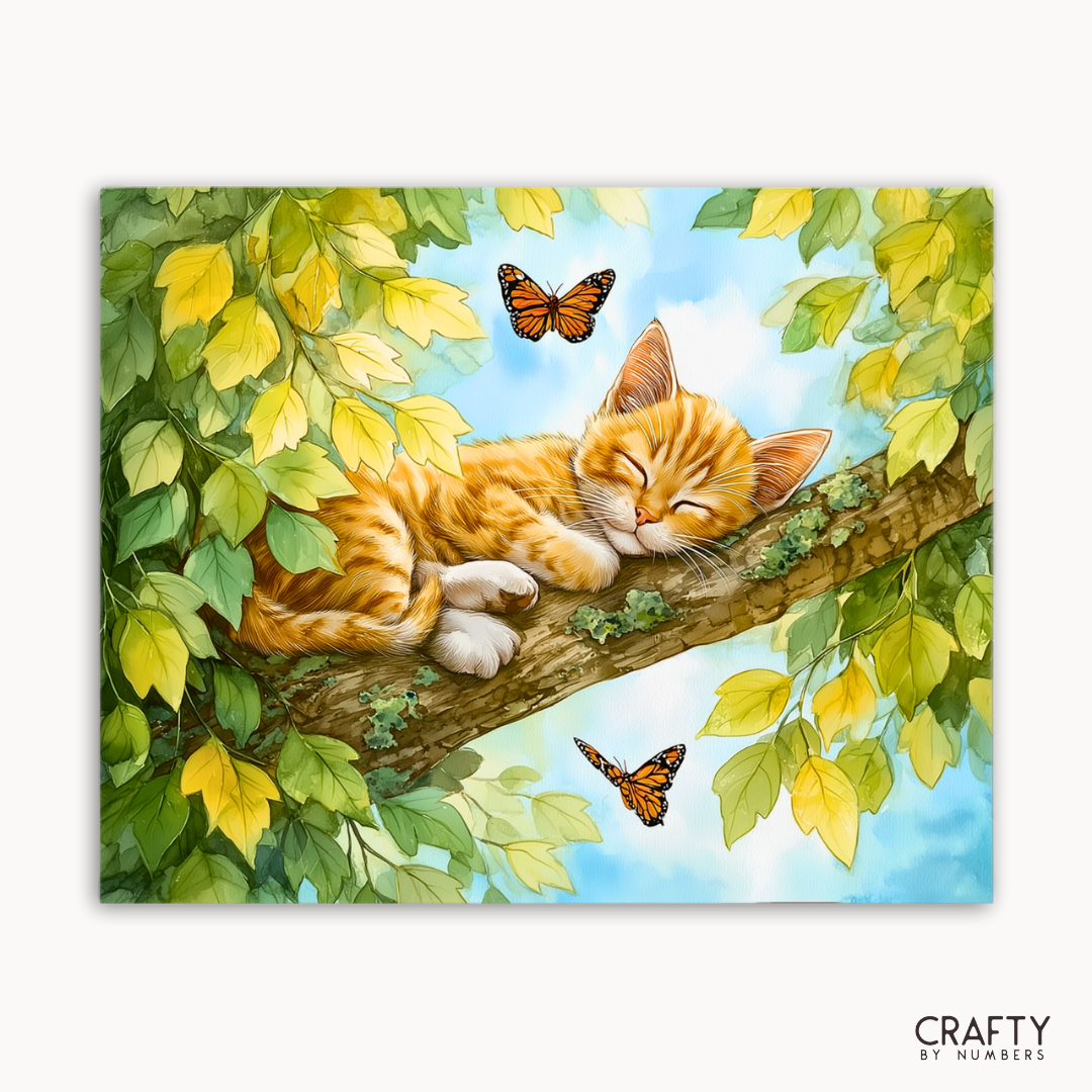 Gemälde einer schlafenden Katze auf einem Ast mit Schmetterlingen und Blättern, Marke „Crafty by Numbers“ sichtbar.
