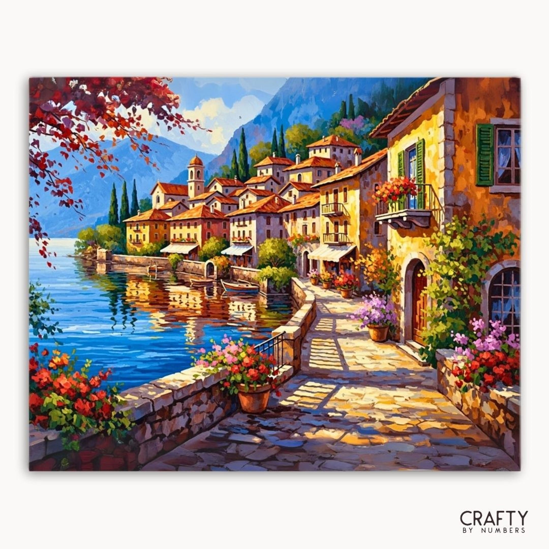 Painting of a picturesque Italian village by a lake with flowers and buildings.