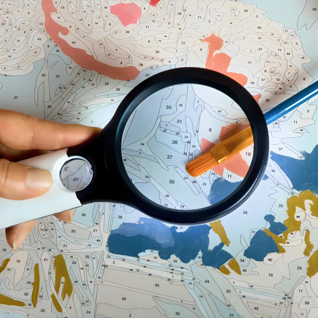 Handheld magnifying glass with ergonomic grip for small canvas sections