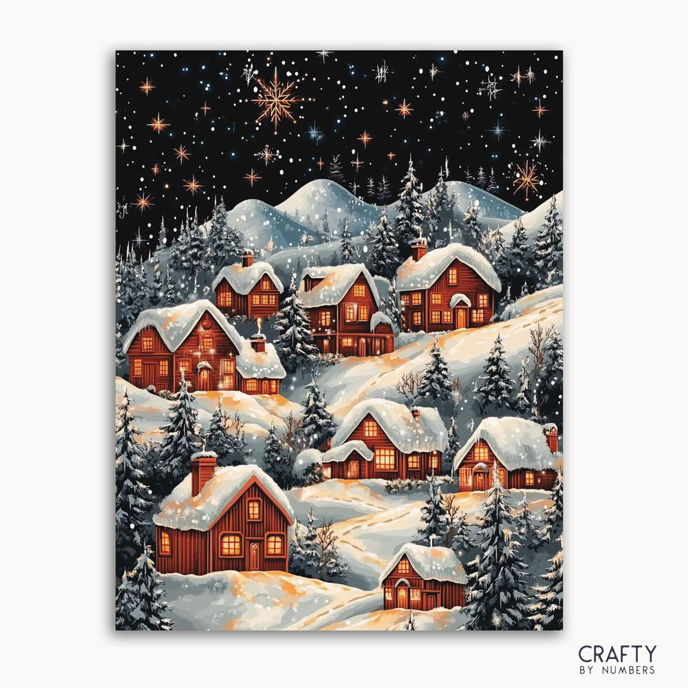 A paint by numbers kit depicting a winter village scene with snow-covered roofs and houses, a starry night sky, and frosted trees.