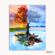 Colorful tree with autumn leaves reflected in water, surrounded by mountains and sky.