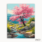 Painting of a cherry blossom tree by a stream with mountains in the background, featuring the brand 'Crafty by Numbers'.
