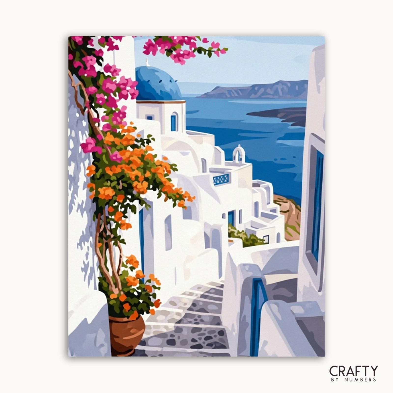 Impresión en lienzo de una vista panorámica con edificios blancos, cielo azul y flores, con la marca 'Crafty by Numbers'.