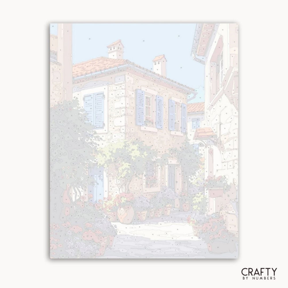 Framed artwork of a snowy village scene with houses and trees, featuring the brand 'Crafty by Numbers'.