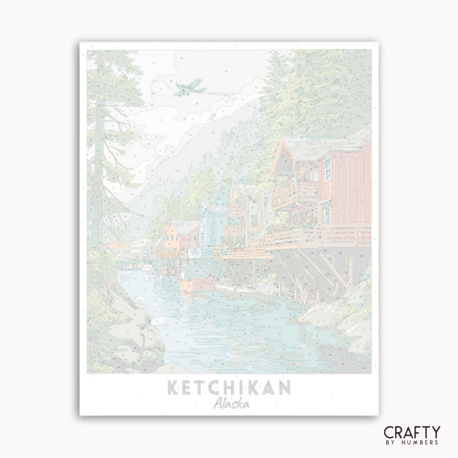 Illustration d'une cabane dans les bois avec le texte « Ketchikan, Alaska » et la marque « Crafty by Numbers ».