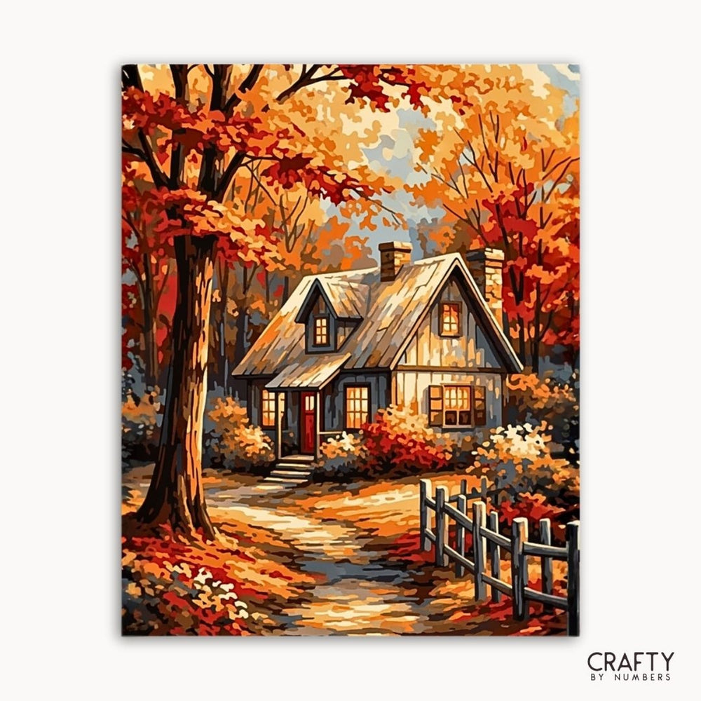 Painting of a cozy house surrounded by autumn trees with 'Crafty by Numbers' branding.