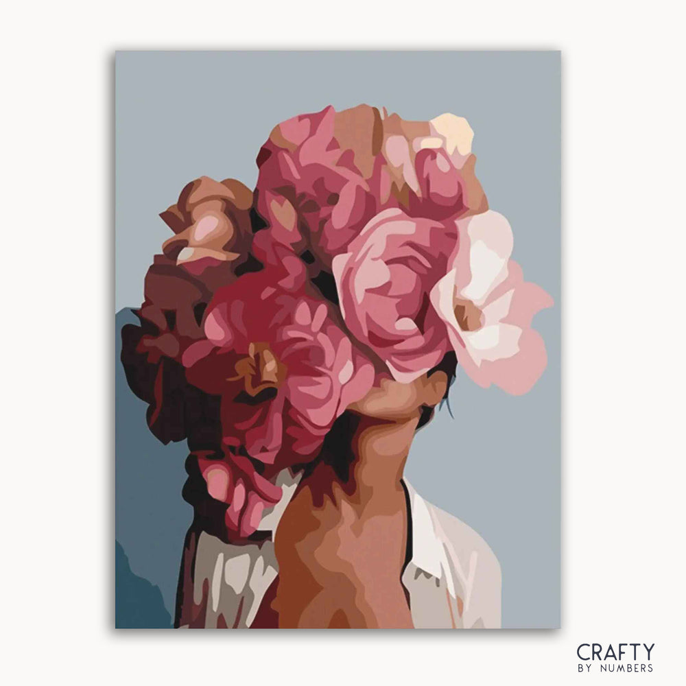 A paint by numbers kit image featuring a woman with a floral crown, predominantly in shades of pink and red.
