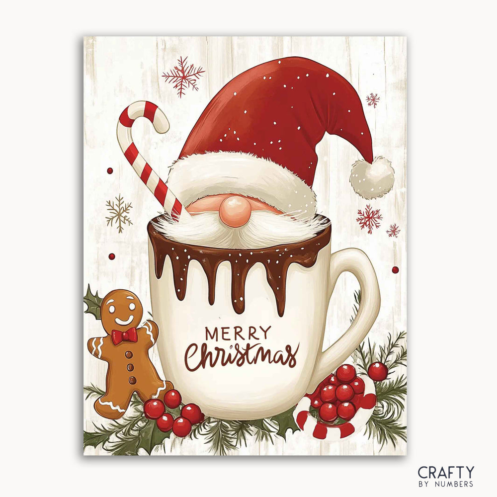 A paint by numbers kit with a festive design featuring Santa Claus wearing a hat, inside a mug filled with cocoa, surrounded by a candy cane, gingerbread man, and Christmas decorations on a white background with 'Merry Christmas' text.
