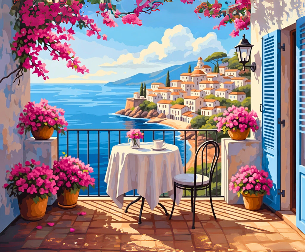 Cozy outdoor seating area with pink flowers and a scenic view of a coastal town.
