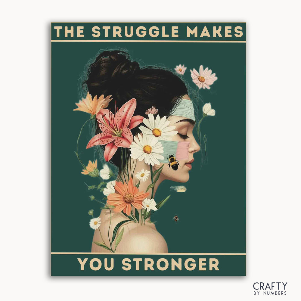 A paint-by-numbers kit with a design of a serene figure with floral adornments and the text 'THE STRUGGLE MAKES YOU STRONGER' across the top.