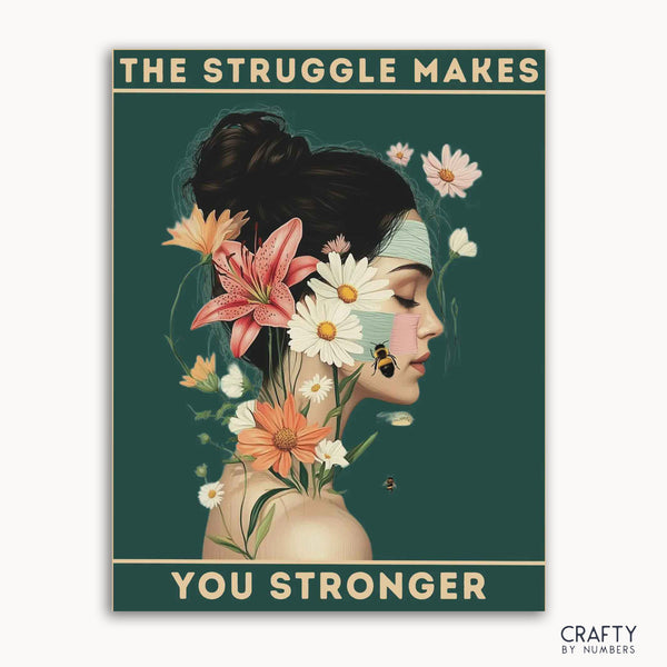 A paint-by-numbers kit with a design of a serene figure with floral adornments and the text 'THE STRUGGLE MAKES YOU STRONGER' across the top.