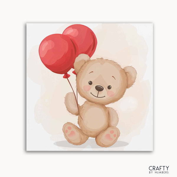 A paint by numbers kit featuring a teddy bear holding two red balloons on a white background with the Crafty by Numbers logo.