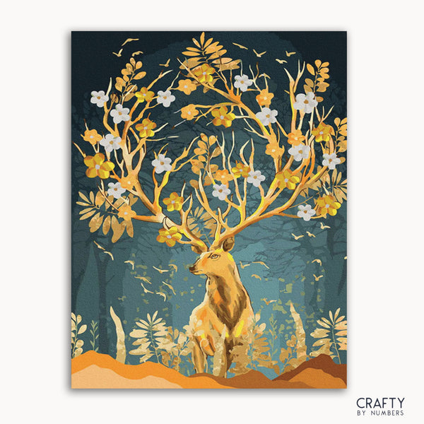 A paint-by-numbers kit depicting a gold-horned deer with antlers shaped like branches, surrounded by a forest and sunlit background.