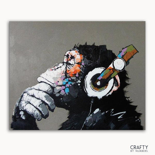 An abstract painting of a monkey with headphones on a framed canvas.