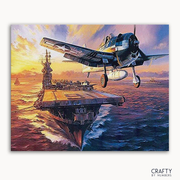 A paint-by-numbers kit depicting a aircraft carrier with a airplane flying over it, against a sea and sunset background.