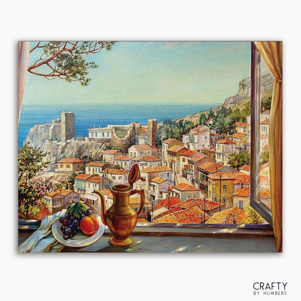 A paint-by-numbers kit depicting a village scene with a sea view, including a vase, grapes, and a plate on a windowsill.