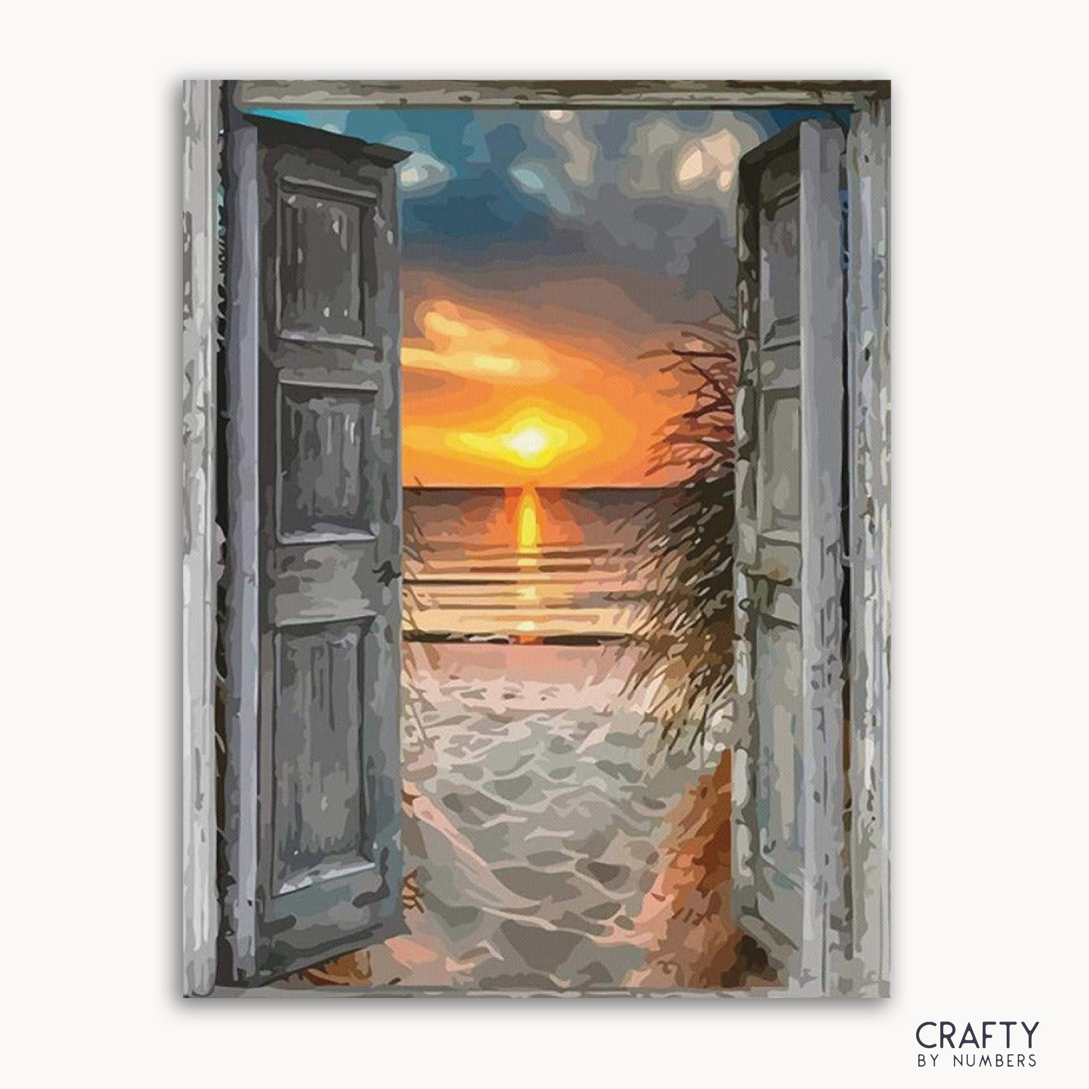 A paint by numbers kit depicting a beach scene with doors open to a sunset over the sea.