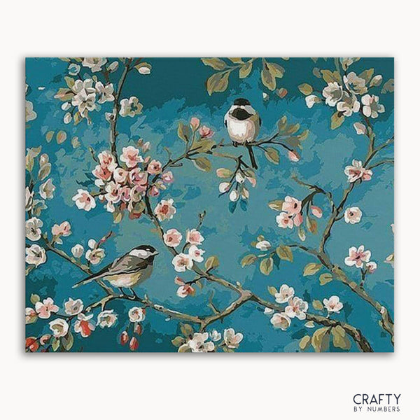 A paint-by-numbers kit image featuring birds on branches with a blue background and floral elements.collection