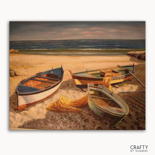 A paint-by-numbers kit image featuring a scene with boats on a beach.